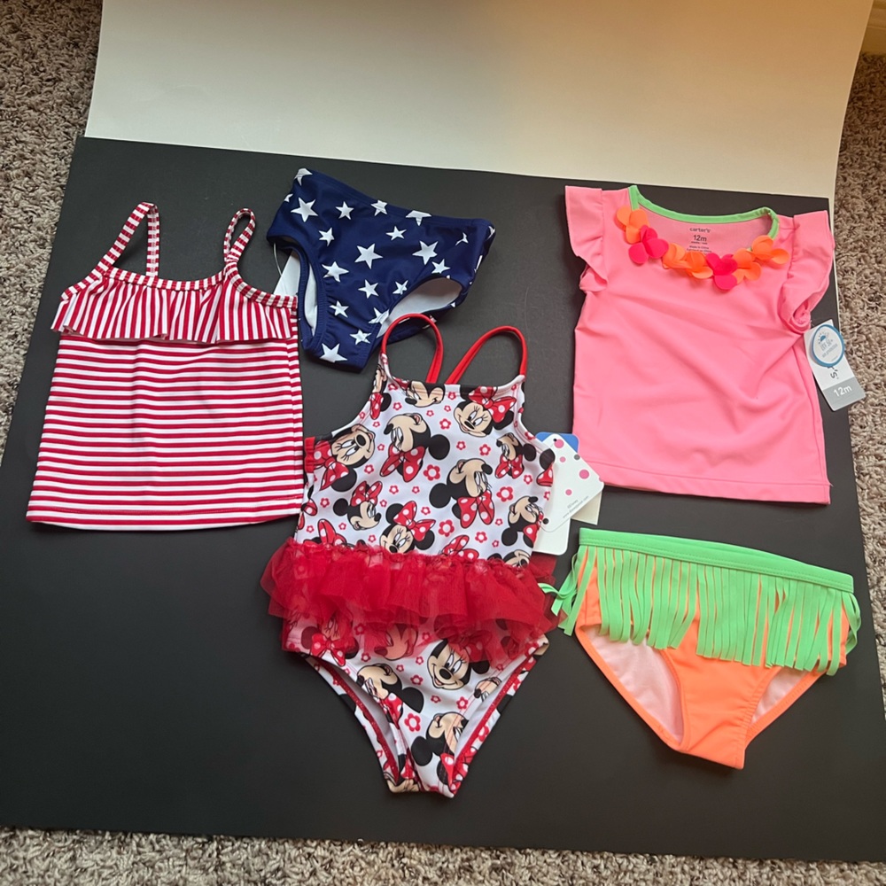 New w/Tags 3 swimwear sets. Size 12M. Includes Osh Kosh, Carters and Disney